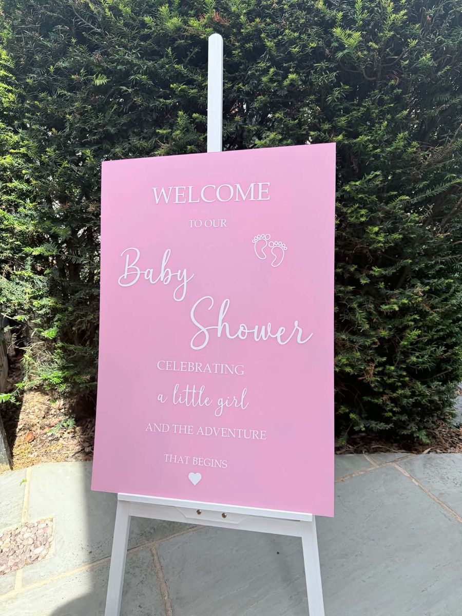 Celebration setup featuring baby shower sign pink