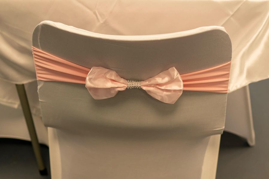 Celebration setup featuring chair sash pink