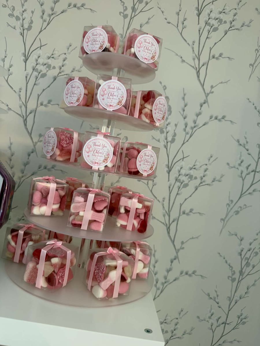 Personalised pink sweet-favour boxes arranged on a tiered stand