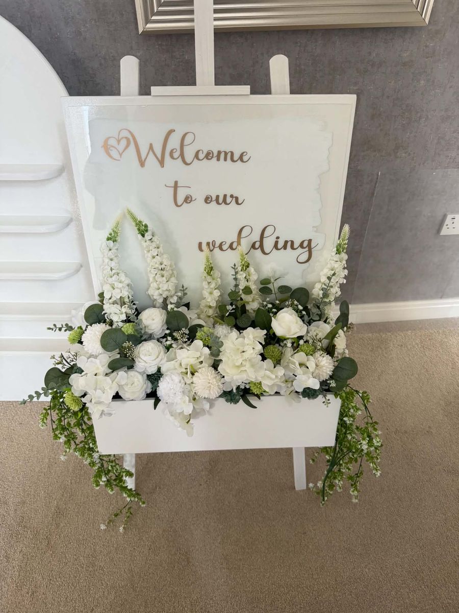 Wedding welcome sign dressed with white flowers
